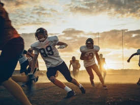 football players on dusty field at sunset