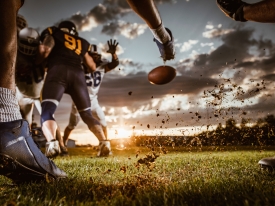 football player kicks football