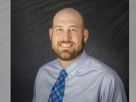 Corporate headshot of a man on a black background