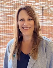 Corporate portrait of a woman in a grey cardigan with long hair 
