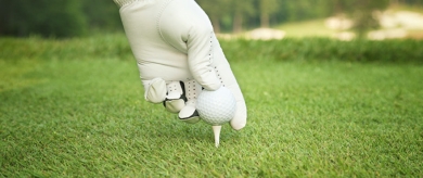 golfball in hand being placed on tee