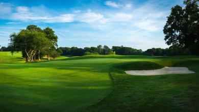 Pristine green fairway and rough on a golf course under a blue sky