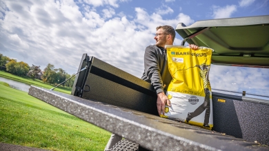 man grabbing seed bag