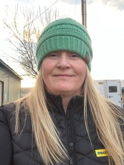 Portrait of woman with long blonde hair and green beanie 
