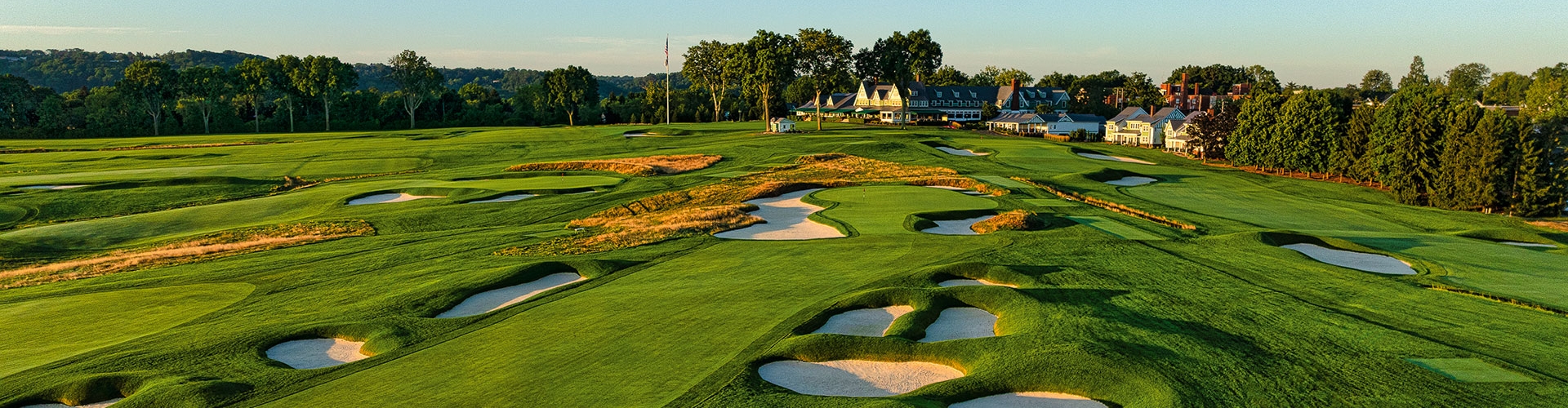 Green golf bunkers at sunset with the golf course clubhouse in the background 